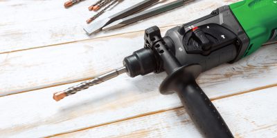 Electric hammer drill lies on a wooden table